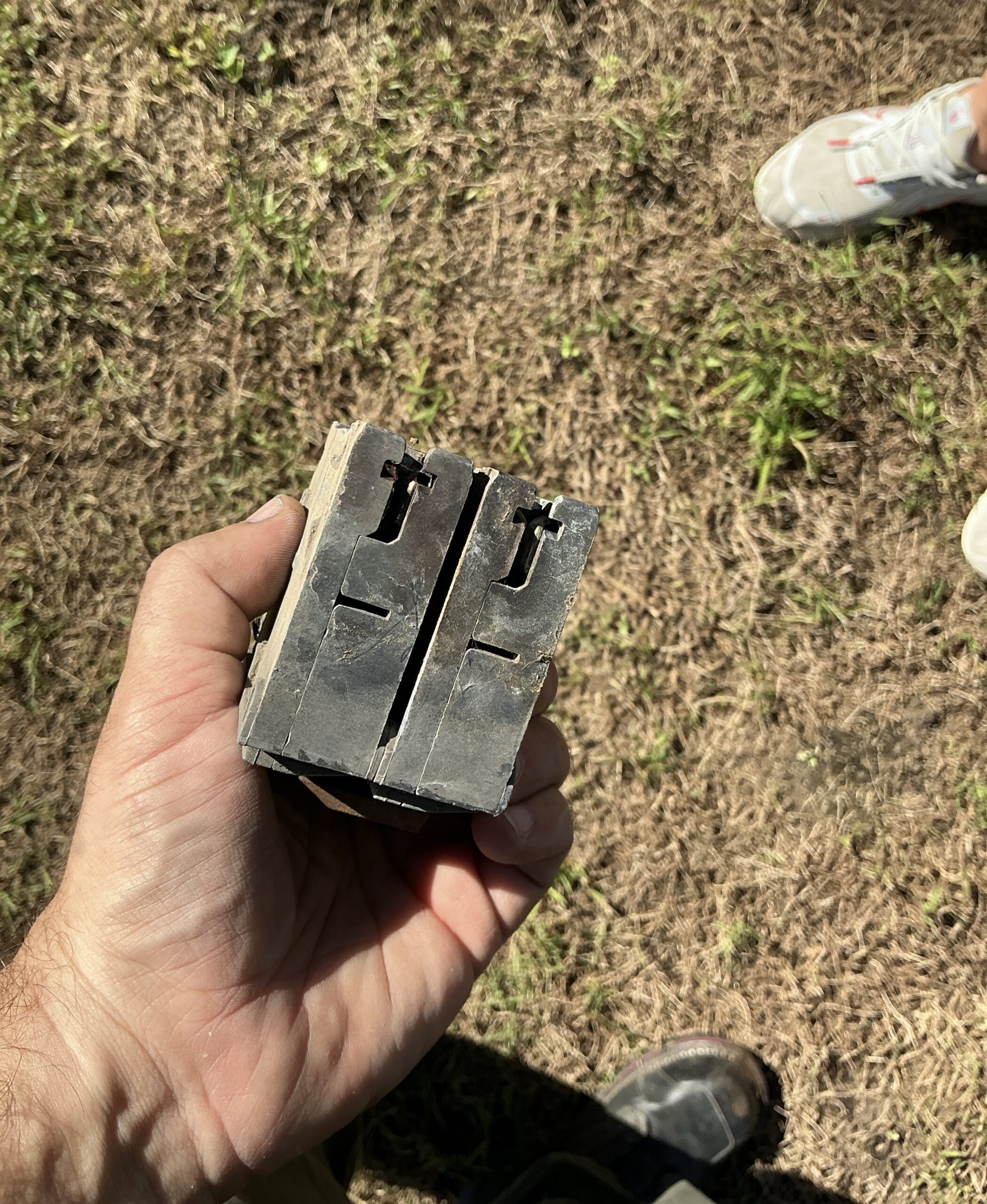 Old 100-amp two-pole main breaker removed from a Johnston, Iowa meter enclosure, with a weathered, cracked casing and blackened handle openings