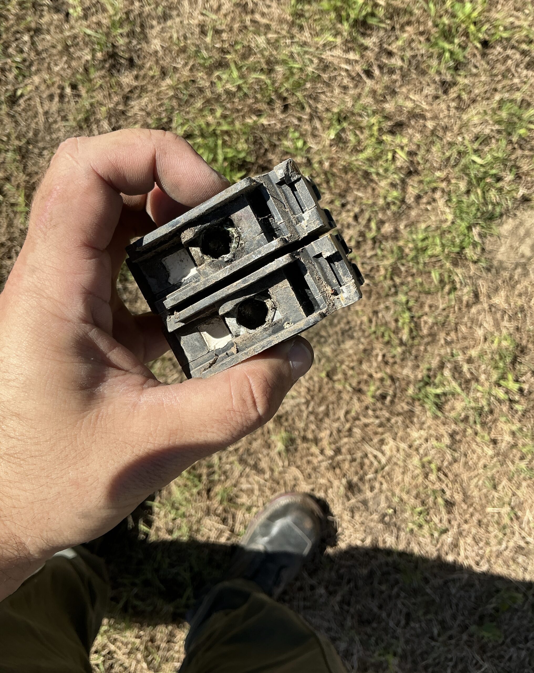 Terminal side of the failed main breaker showing debris and heat-damaged plastic around the lug openings